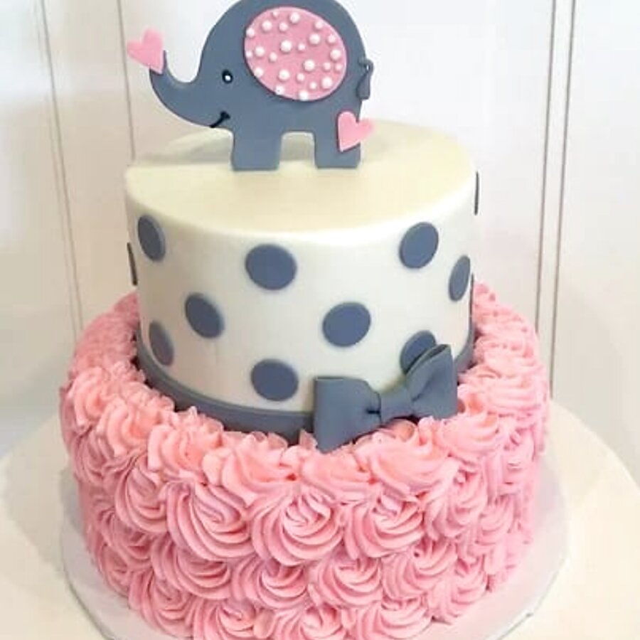 Pastel real de baby shower con elefante y rosetas rosadas