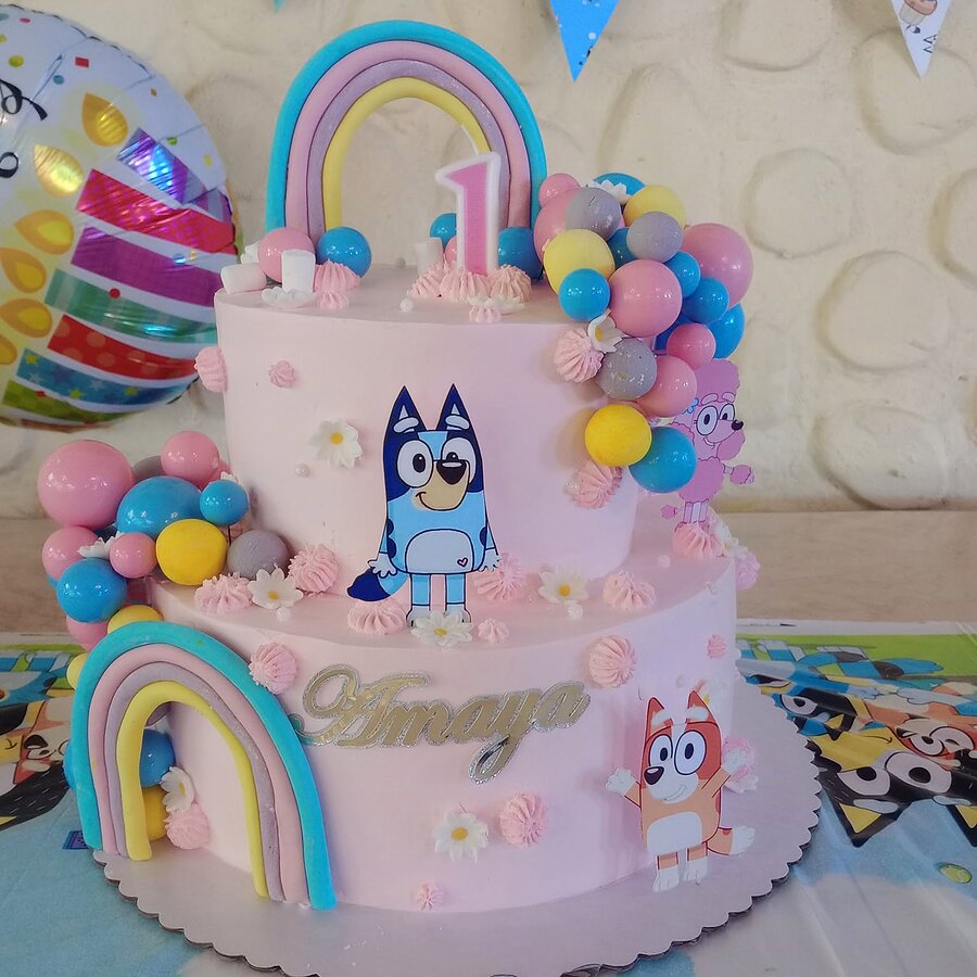Pastel real temático infantil rosado con arcoíris y personajes